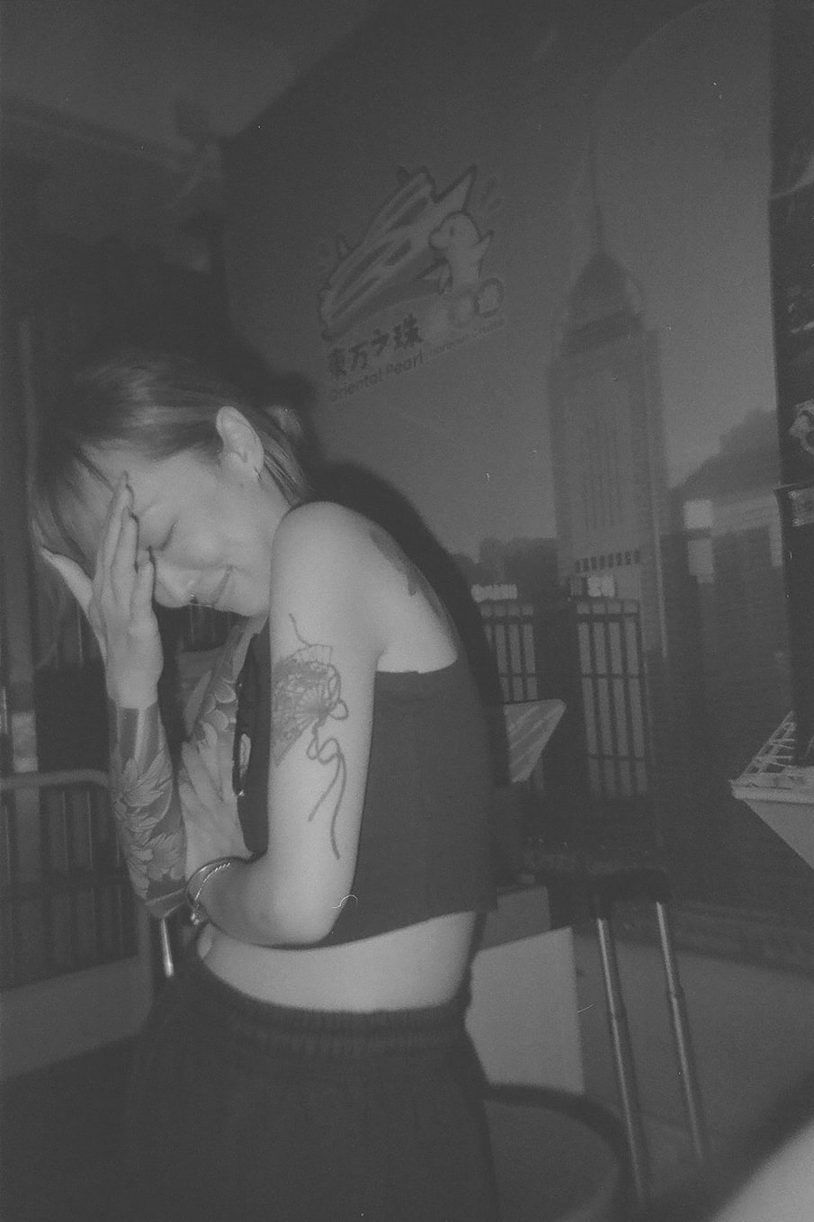 Guest resting against an Oriental Pearl mural, shot in black and white