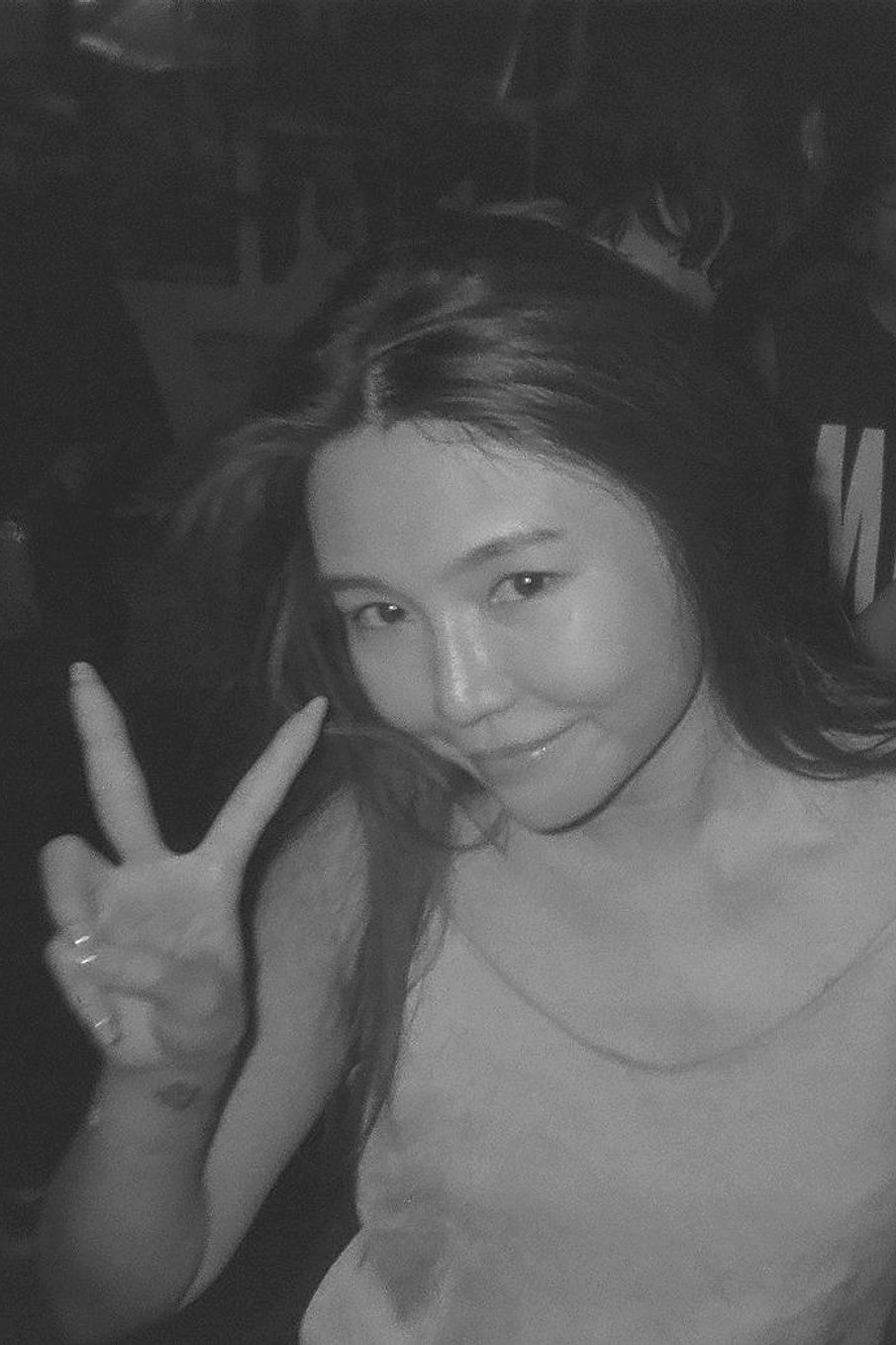 Guest throwing a peace sign on the dance floor, shot in black and white